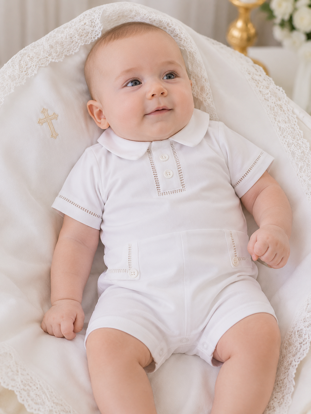 Baby in a white outfit sitting on a white textured surface
