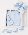 Blue baby outfit with 'Oliver' embroidered, in a white box with a blue ribbon on a light gray background