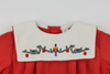 Embroidered design on a red and white fabric with Christmas-themed elements.