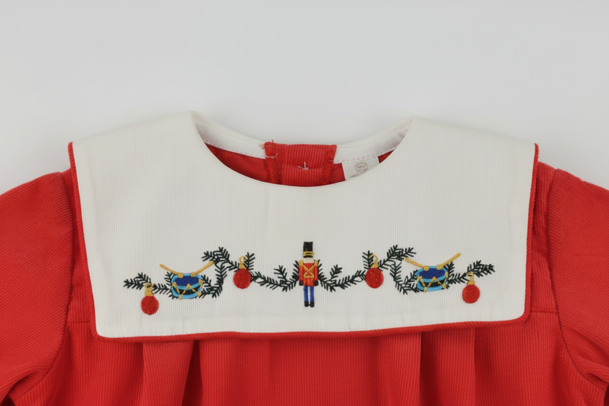 Embroidered design on a red and white fabric with Christmas-themed elements.
