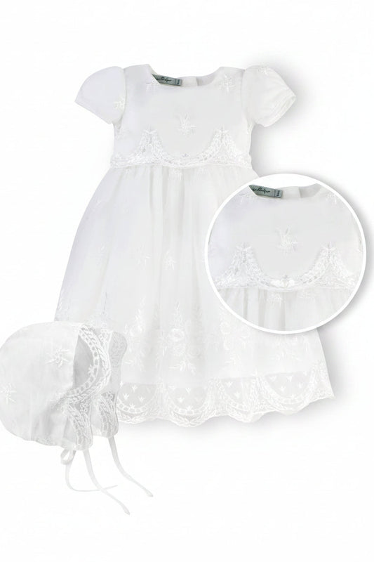 White baby dress with lace details and matching bonnet on a white background