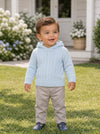 Carriage Boutique baby blue cable knit hooded sweater worn by a toddler standing on a green lawn.