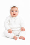 Carriage Boutique baby boy white knit baptism outfit with pearl cross detail and matching bonnet on a seated baby.