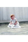 Carriage Boutique baby boy wearing a white christening gown with hand-smocked yoke and baby blue bullion cross design