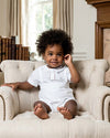 Carriage Boutique baby boy wearing a white linen cotton christening short set with hand embroidered details
