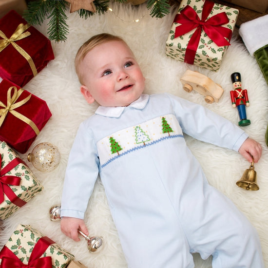 Carriage Boutique baby boy light blue longall with smocked Christmas tree embroidery on a festive holiday background