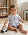 Carriage Boutique baby boy bubble romper in light blue cotton with hand-smocked police car embroidery and white collar