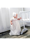 Carriage Boutique baby girl christening gown with pink bullion cross embroidery, smocked yoke, and matching ruffled bonnet