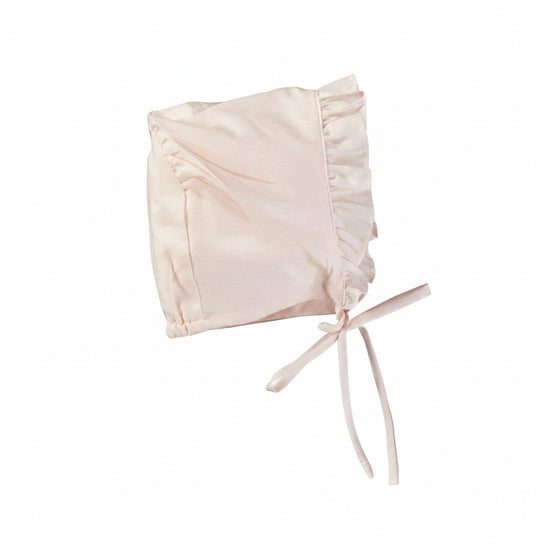 Carriage Boutique baby girl bonnet in soft pink cotton with delicate ruffled trim and tie closure.
