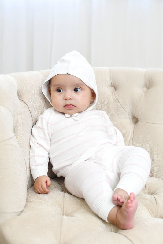 Carriage Boutique baby wearing a creamy white knit set with blush pink stripes, long sleeves, leggings, and a matching hat.