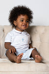 Carriage Boutique baby boy's light blue smocked christening bobbie suit with blue cross embroidery and Peter Pan collar.