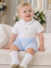 Carriage Boutique white cotton bobbie suit with blue smocking, cross detail, and light blue shorts for baby boys.