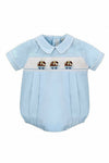 Carriage Boutique light blue cotton baby boy bubble romper with hand-smocked white panel featuring blue dogs in wagons.