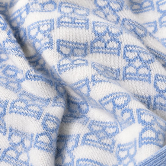 Carriage Boutique baby knit blanket featuring a soft white and blue monogram pattern with a ribbed edge.