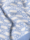 Carriage Boutique baby knit blanket featuring a soft white and blue monogram pattern with a ribbed edge.