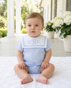 Carriage Boutique baby boy bubble romper in light blue and white with a monogrammed Peter Pan collar on a toddler.