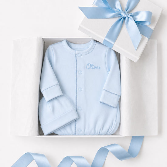 Carriage Boutique blue newborn sleep sack with matching hat and personalized embroidery in a gift box.