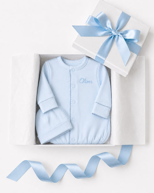 Carriage Boutique blue newborn sleep sack with matching hat and personalized embroidery in a gift box.