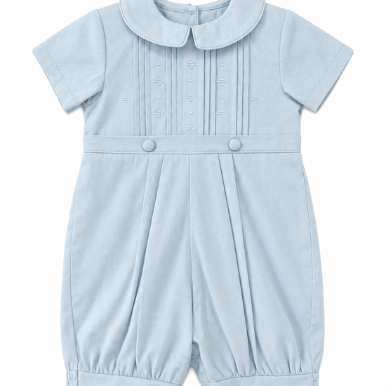 Carriage Boutique baby boy blue pique romper with a Peter Pan collar, pleated bodice, and button detailing.