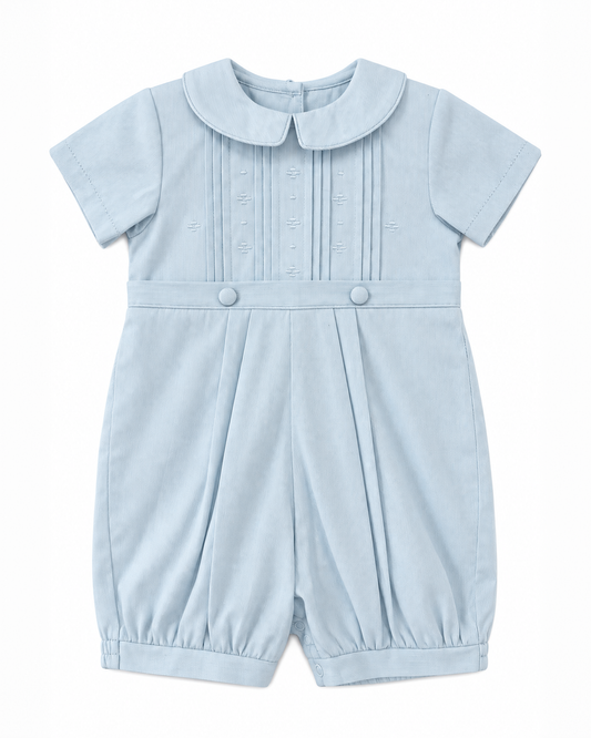 Carriage Boutique baby boy blue pique romper with a Peter Pan collar, pleated bodice, and button detailing.