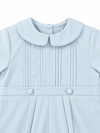 Carriage Boutique baby boy light blue pique romper with a Peter Pan collar, pleated front, and decorative buttons.