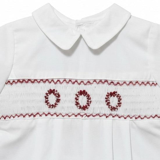Carriage Boutique boys white batiste shortall with red hand-smocked holiday wreath embroidery and Peter Pan collar.