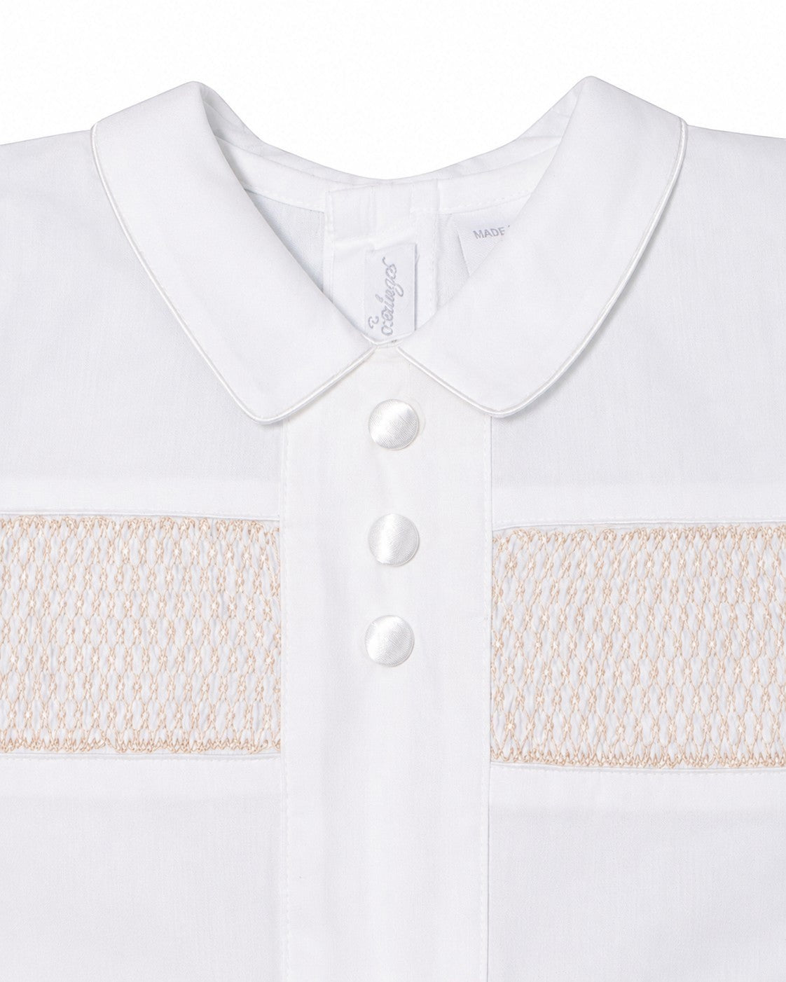 Carriage Boutique white cotton boys christening outfit featuring delicate hand-smocked detail and satin button trim.