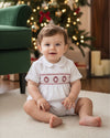 Carriage Boutique white batiste boys shortall with red hand-smocked holiday wreath detail, worn by a baby boy.