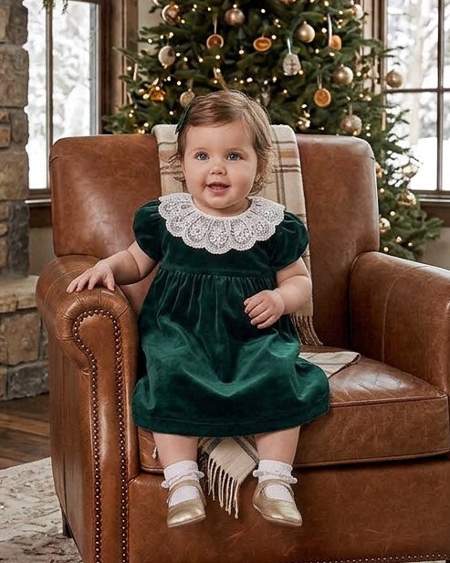 Carriage Boutique green velvet dress with white lace collar worn by a toddler sitting in a leather chair