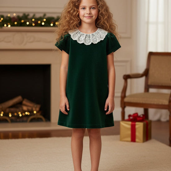 Carriage Boutique toddler green velvet dress with a delicate white lace collar worn by a young girl in a festive room
