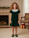 Carriage Boutique toddler green velvet dress with a delicate white lace collar worn by a young girl in a festive room
