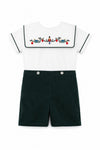 Carriage Boutique infant boy bobbie suit featuring a white shirt with a wooden soldier motif and green corduroy shorts