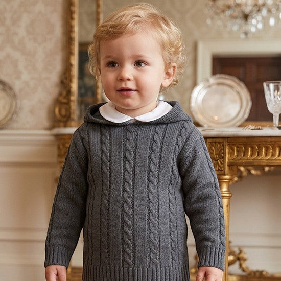 Carriage Boutique baby boy wearing a dark grey cable-knit cotton sweater with a hood and ribbed trim