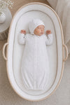 Carriage Boutique infant sleep gown and matching bonnet in white with grey star print, worn by a sleeping newborn.