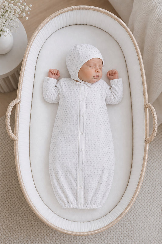Carriage Boutique infant sleep gown and matching bonnet in white with grey star print, worn by a sleeping newborn.
