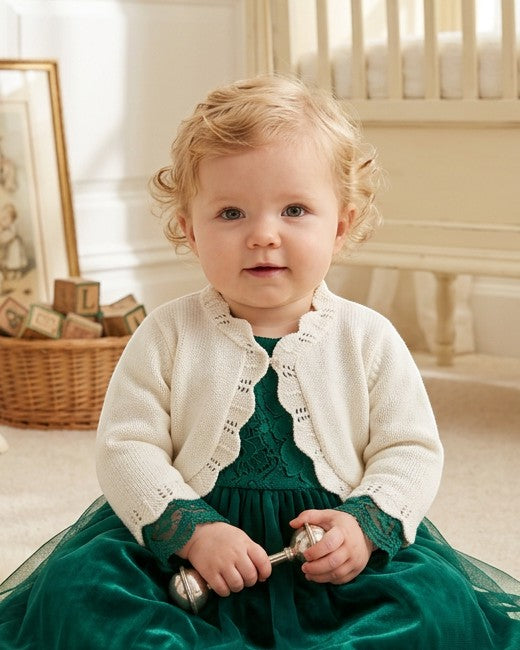 Carriage Boutique ivory cotton bolero shrug sweater with delicate scalloped edges worn by a baby girl