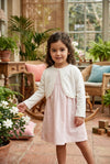 Carriage Boutique ivory knit bolero sweater worn by a young girl in a sunlit garden setting