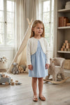 Carriage Boutique ivory knit bolero sweater worn by a young girl over a light blue dress in a nursery setting