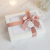 Carriage Boutique Julius Berger white baby blanket with lace trim in a gift box with a dusty rose satin ribbon bow.