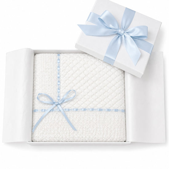 Carriage Boutique Julius Berger white baby blanket with delicate Belgium lace and a light blue ribbon in a gift box