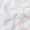 Carriage Boutique Julius Berger white knit baby blanket with delicate pink satin ribbon trim and a sweet bow accent.