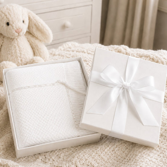 Carriage Boutique Julius Berger white baby blanket with lace trim in a gift box with a satin ribbon bow