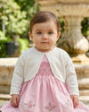 Carriage Boutique Julius Berger white knit bolero sweater worn by a baby girl over a pink embroidered dress