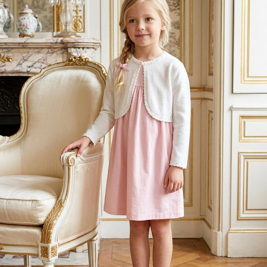Carriage Boutique white Julius Berger bolero sweater worn by a young girl in a pink dress in a classic room.