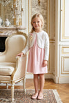 Carriage Boutique white Julius Berger bolero sweater worn by a young girl in a pink dress in a classic room.
