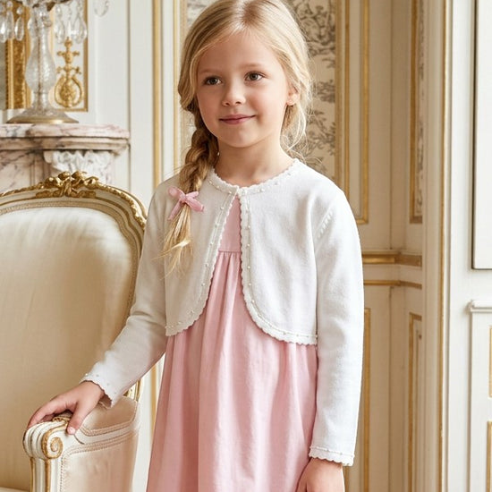 Carriage Boutique white Julius Berger bolero sweater with pearl trim worn by a young girl over a pink dress