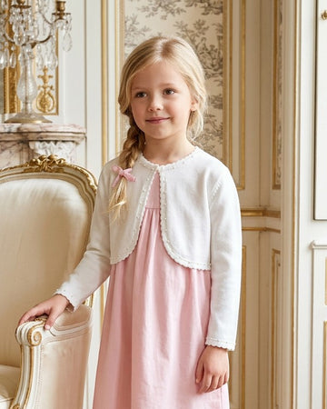 Carriage Boutique white Julius Berger bolero sweater with pearl trim worn by a young girl over a pink dress