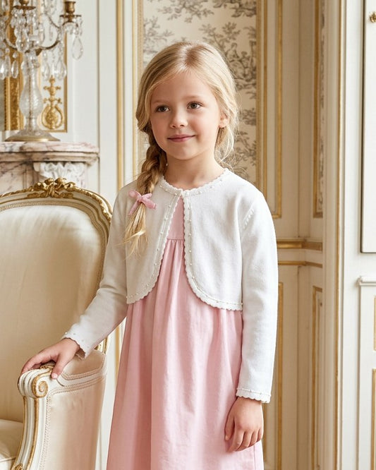 Carriage Boutique white Julius Berger bolero sweater with pearl trim worn by a young girl over a pink dress