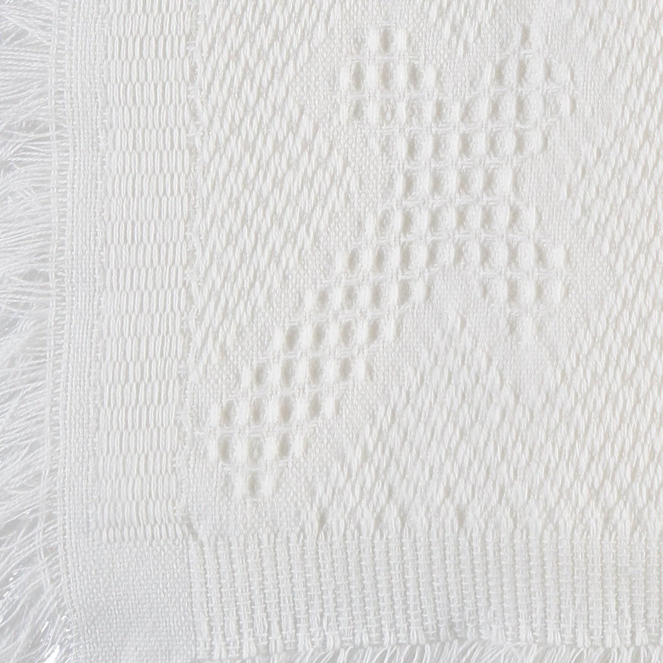 Carriage Boutique Julius Berger white knit baby blanket featuring a delicate textured cross pattern and fringe edge