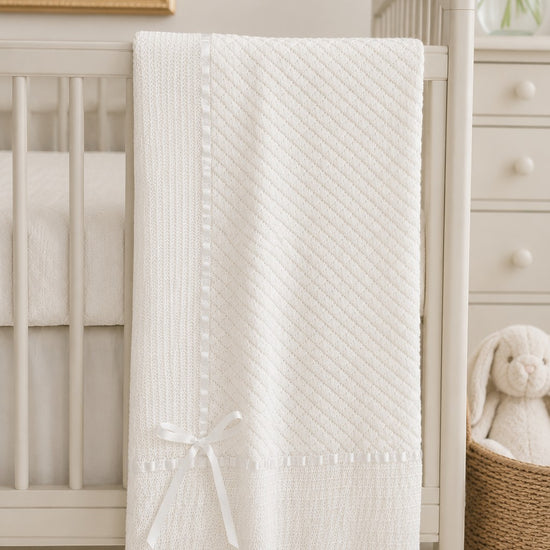 Carriage Boutique Julius Berger white baby blanket with elegant Belgium lace trim and a delicate satin ribbon bow
